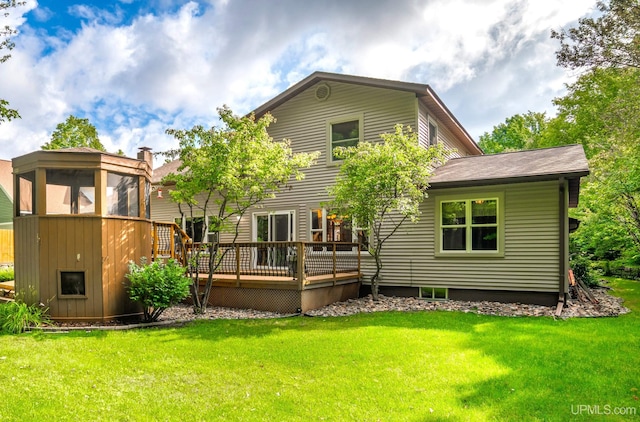 rear view of property featuring a wooden deck, a sunroom, and a yard