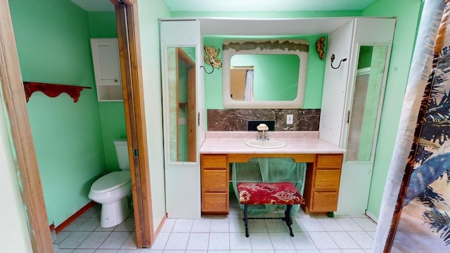 bathroom featuring decorative backsplash, vanity, tile patterned floors, and toilet