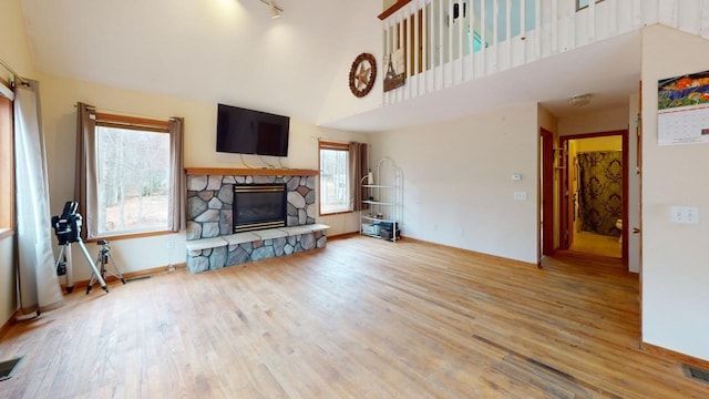 living room featuring light hardwood / wood-style floors, a healthy amount of sunlight, and a fireplace