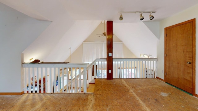 hall with track lighting and lofted ceiling