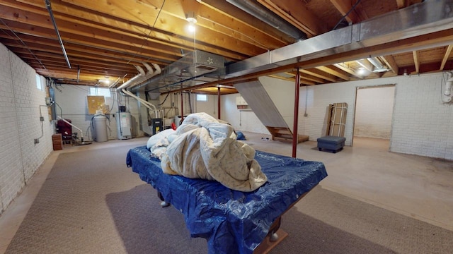 basement with water heater and brick wall