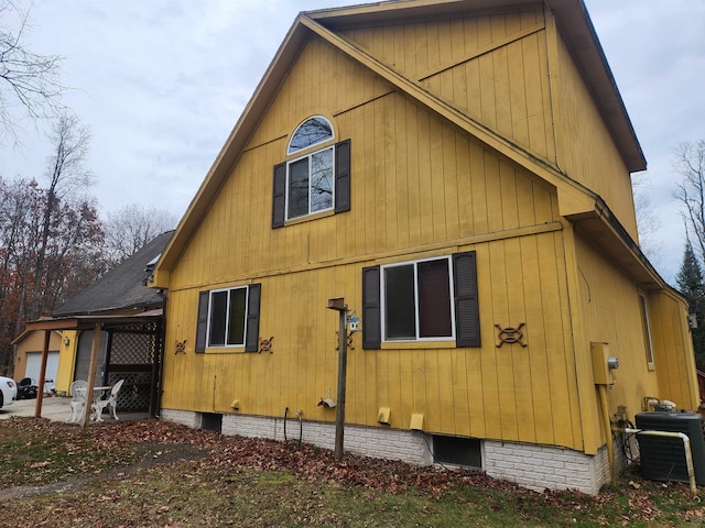 view of side of home with central AC unit and a patio area