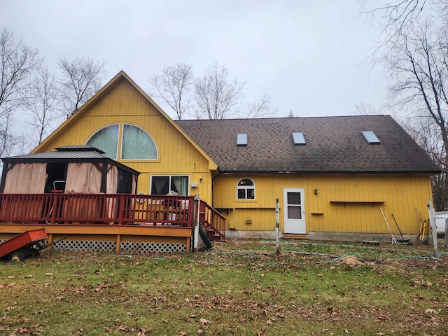 rear view of house with a wooden deck and a yard