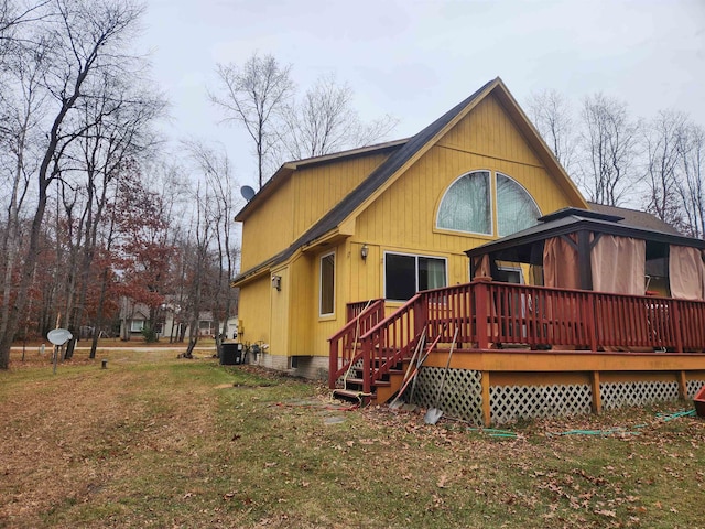 back of property with a deck and a yard