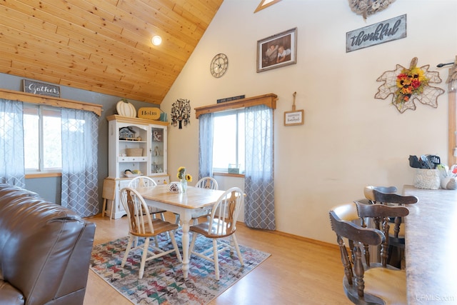 dining room featuring high vaulted ceiling, light wood-type flooring, and wood ceiling