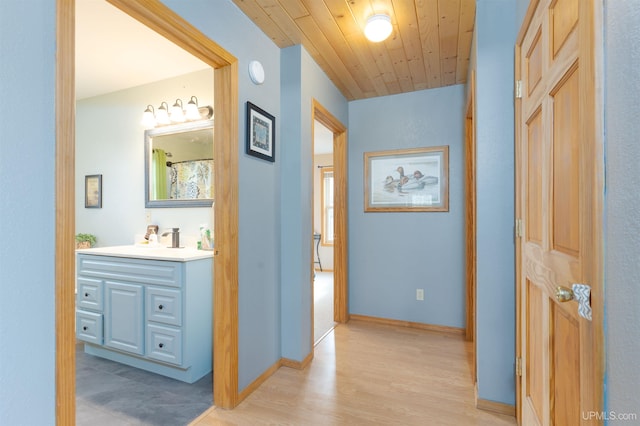 371 Morrison Creek Rd, Iron River, MI 49935 - hallway featuring baseboards, light wood-style floors, wood ceiling, and a sink