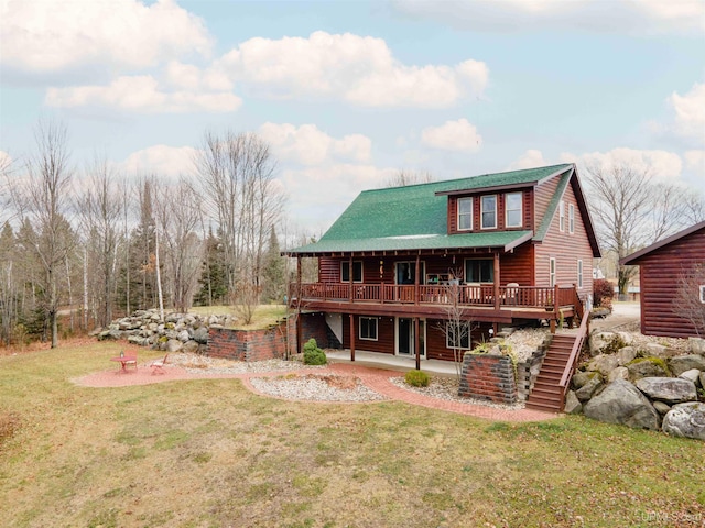 rear view of property with a wooden deck and a lawn