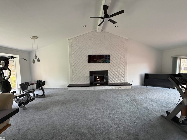 exercise room featuring a large fireplace, carpet floors, ceiling fan, and lofted ceiling