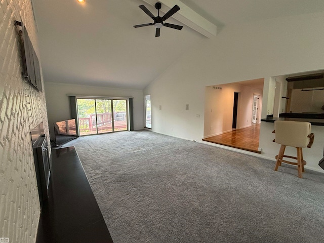 unfurnished living room with high vaulted ceiling, carpet, ceiling fan, and beam ceiling