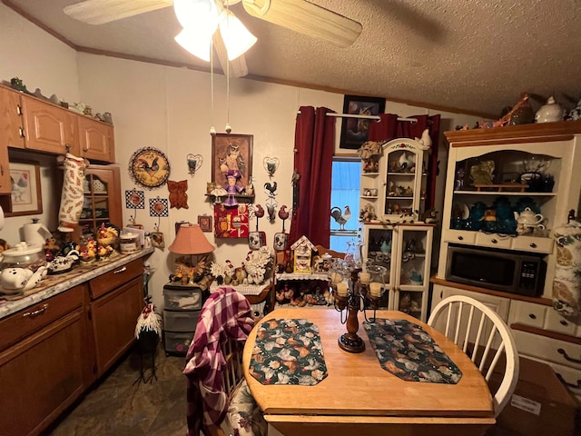 dining space featuring ceiling fan and a textured ceiling