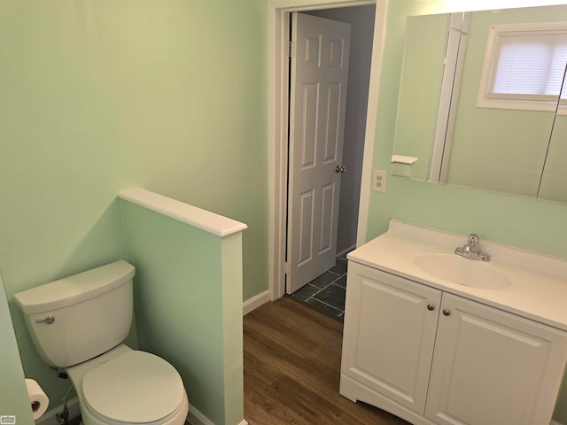 bathroom with hardwood / wood-style flooring, vanity, and toilet