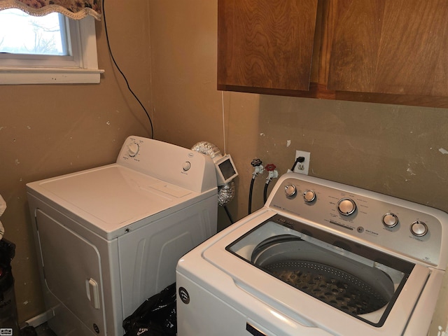 washroom with washer and clothes dryer and cabinets