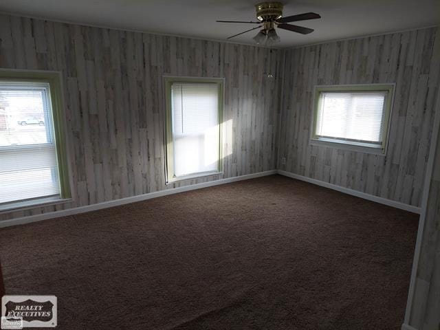 carpeted spare room featuring ceiling fan