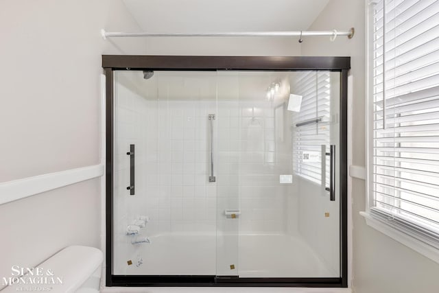 bathroom with toilet and enclosed tub / shower combo