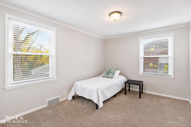 carpeted bedroom with a textured ceiling and crown molding