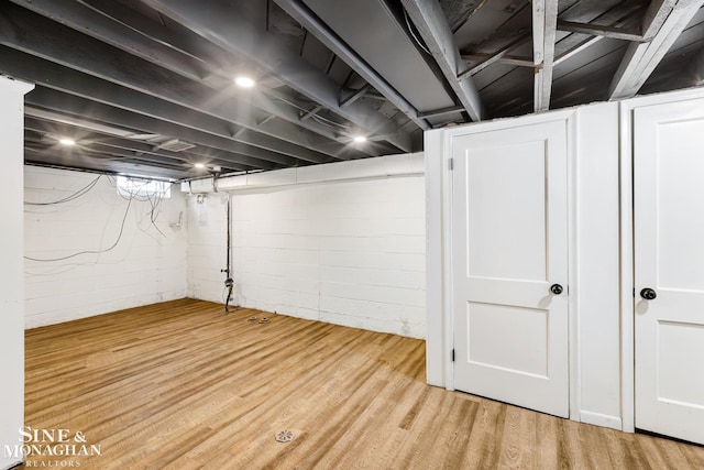 basement with light hardwood / wood-style flooring