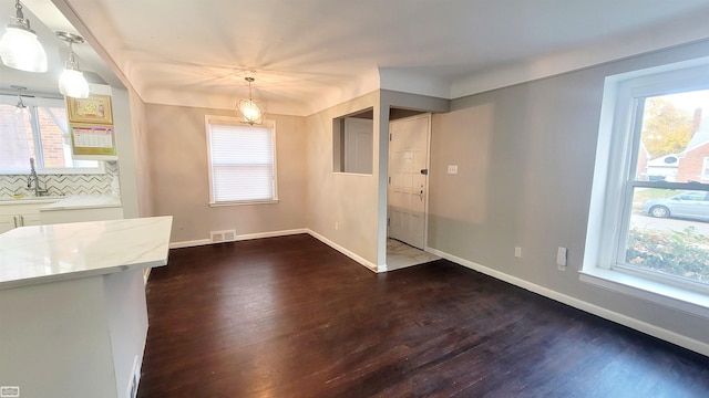 unfurnished dining area featuring sink and dark hardwood / wood-style flooring