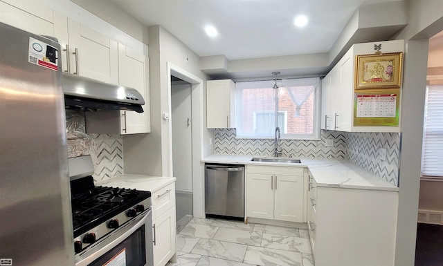 kitchen featuring white cabinets, hanging light fixtures, sink, light stone countertops, and appliances with stainless steel finishes