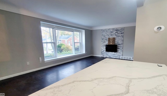 unfurnished living room with a fireplace and dark hardwood / wood-style floors