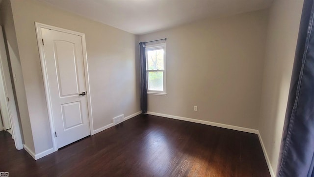 spare room with dark hardwood / wood-style flooring