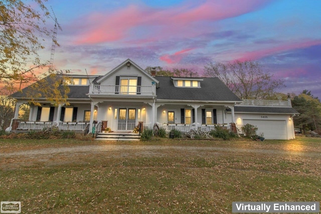 view of front of house with a garage, a yard, covered porch, and a balcony