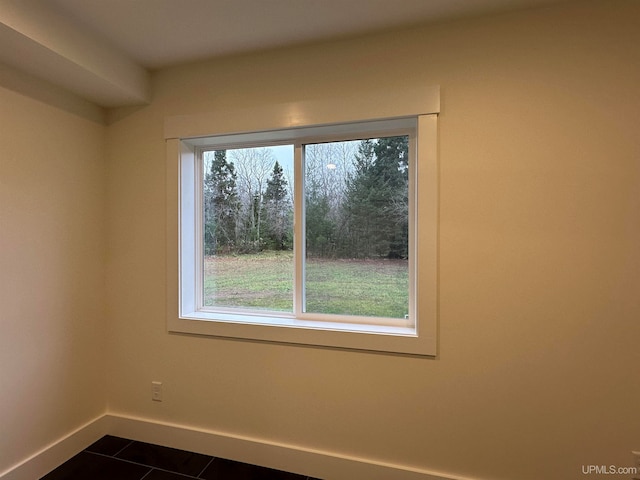 tiled spare room featuring a wealth of natural light