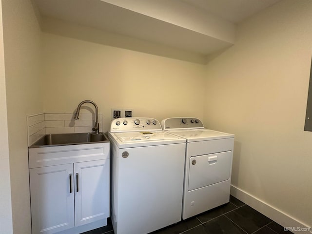 laundry area featuring cabinets, washer and dryer, sink, and dark tile patterned flooring