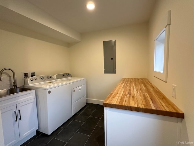 washroom featuring cabinets, separate washer and dryer, sink, electric panel, and dark tile patterned flooring