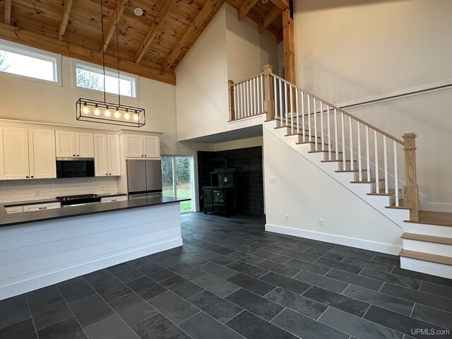 11881 N Junet Rd, Ironwood, MI 49938 - kitchen featuring high vaulted ceiling, wood ceiling, dark countertops, stainless steel fridge, and white cabinets