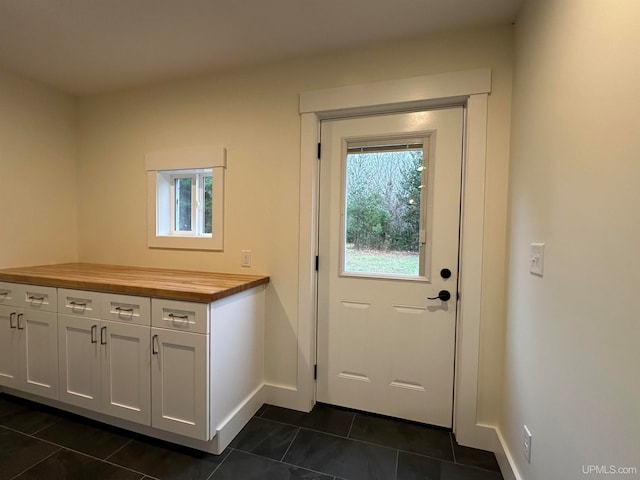 doorway with dark tile patterned flooring