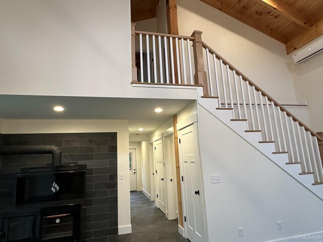 11881 N Junet Rd, Ironwood, MI 49938 - staircase with recessed lighting, wooden ceiling, a wall unit AC, a towering ceiling, and beamed ceiling