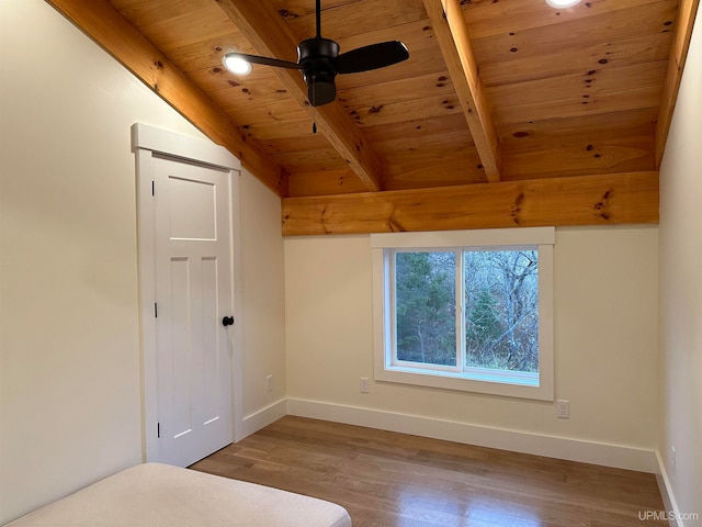 unfurnished bedroom with ceiling fan, vaulted ceiling with beams, hardwood / wood-style flooring, and wooden ceiling