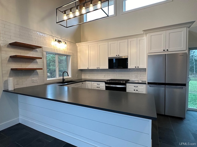 kitchen featuring stainless steel appliances, dark tile patterned floors, white cabinetry, backsplash, and sink