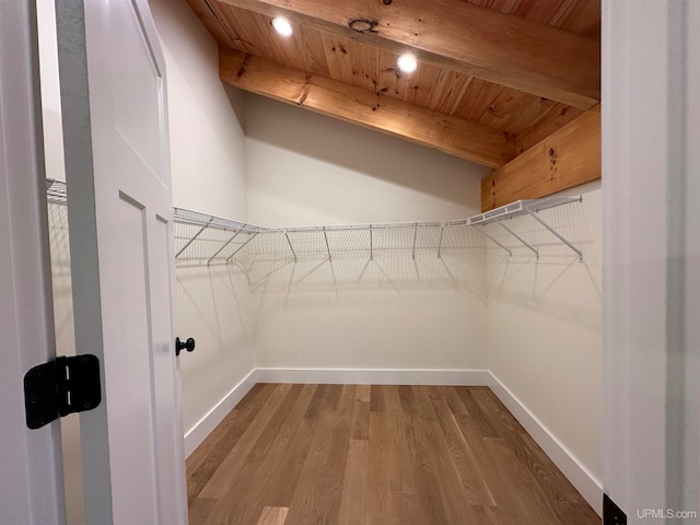 spacious closet with hardwood / wood-style flooring and beam ceiling