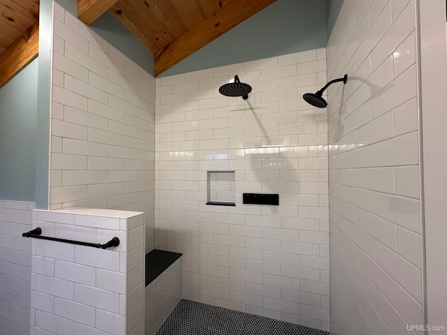 bathroom with lofted ceiling with beams, wood ceiling, tiled shower, and tile walls