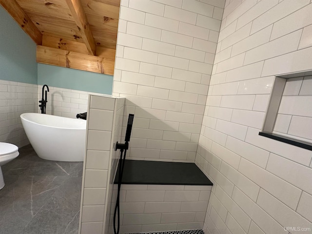 bathroom featuring toilet, tile walls, a washtub, wooden ceiling, and beam ceiling