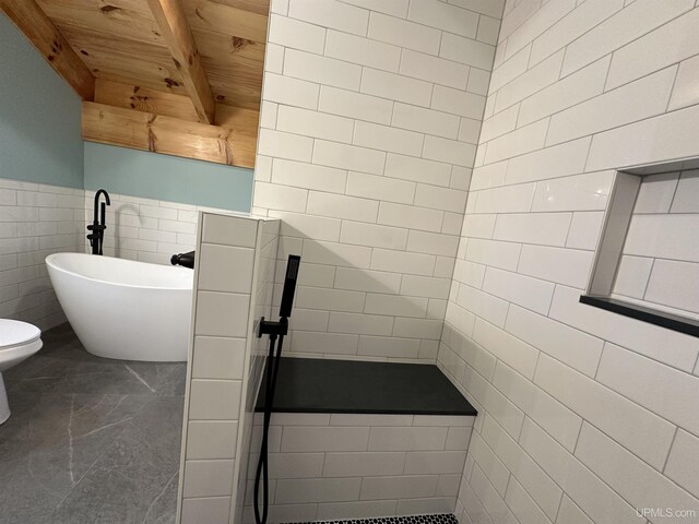 11881 N Junet Rd, Ironwood, MI 49938 - full bathroom featuring tile walls, a freestanding tub, beamed ceiling, and wooden ceiling