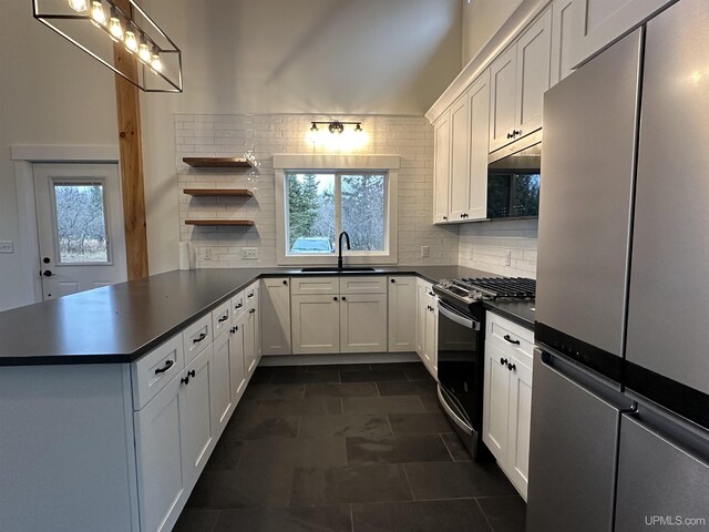 11881 N Junet Rd, Ironwood, MI 49938 - kitchen featuring stainless steel appliances, dark countertops, backsplash, a peninsula, and open shelves