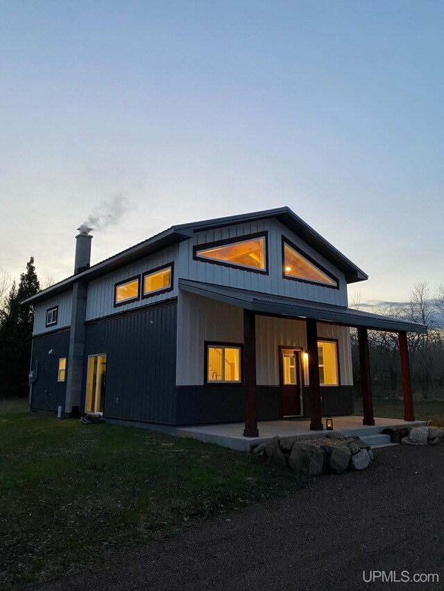 11881 N Junet Rd, Ironwood, MI 49938 - back of house at dusk with a chimney and a porch