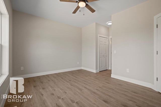 spare room with a ceiling fan, wood finished floors, and baseboards