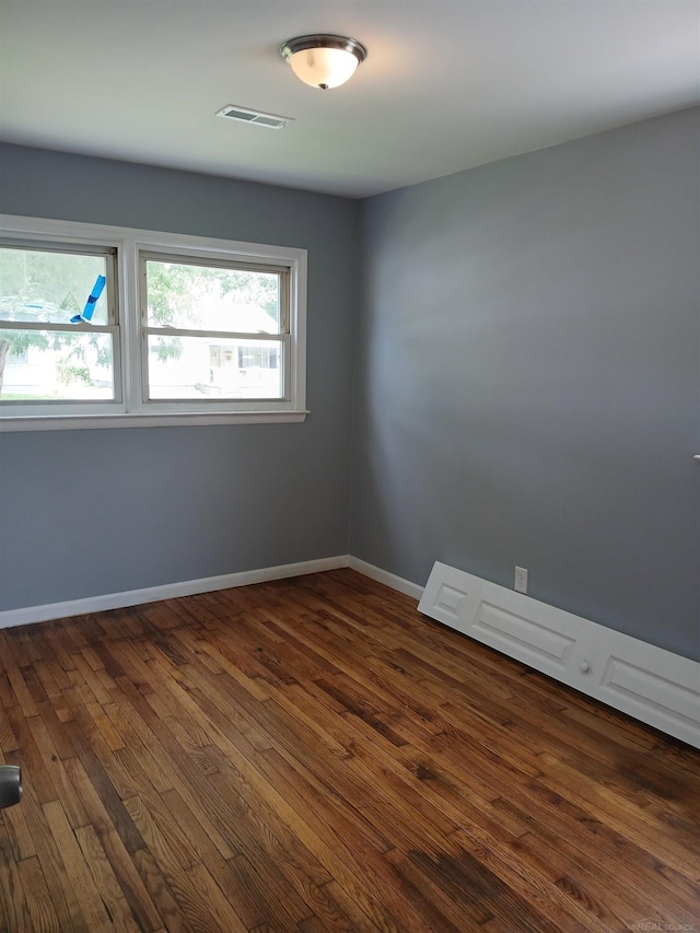 unfurnished room with dark hardwood / wood-style flooring