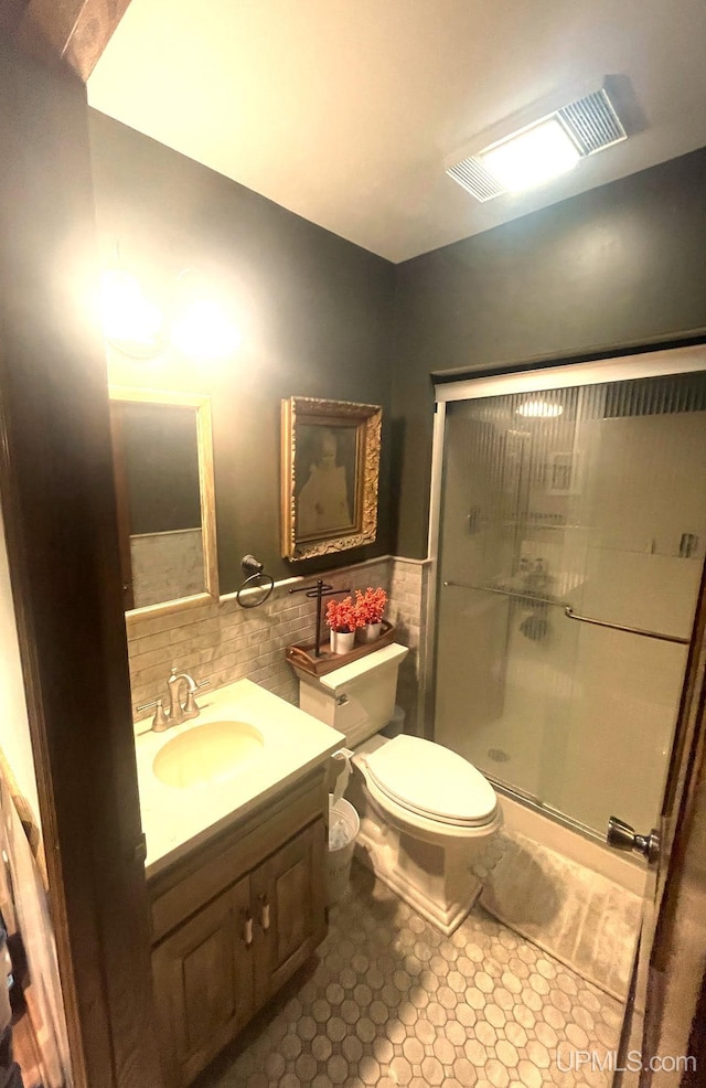 bathroom featuring vanity, toilet, tile walls, and walk in shower