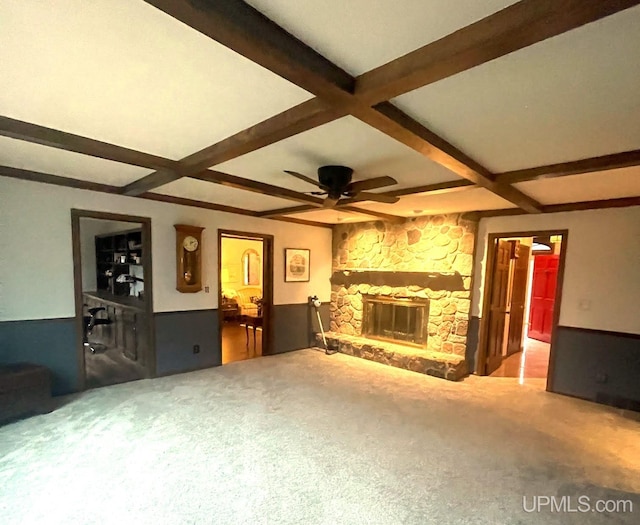 unfurnished living room with coffered ceiling, carpet flooring, ceiling fan, a fireplace, and beam ceiling