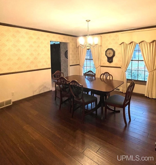 dining room featuring an inviting chandelier, plenty of natural light, dark wood-type flooring, and crown molding