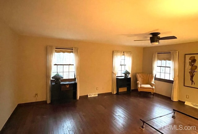 unfurnished room with dark hardwood / wood-style floors, plenty of natural light, and ceiling fan