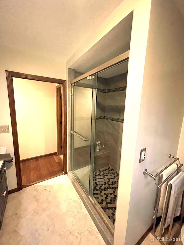 bathroom with hardwood / wood-style floors, vanity, and a shower with door