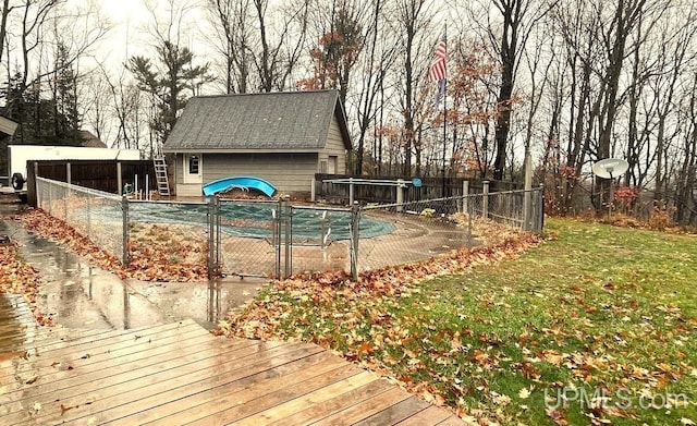 view of pool featuring an outbuilding, a yard, and a deck