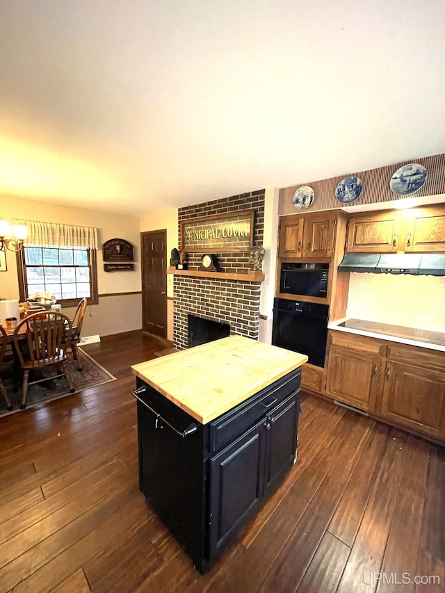 kitchen with a fireplace, dark hardwood / wood-style floors, and black appliances