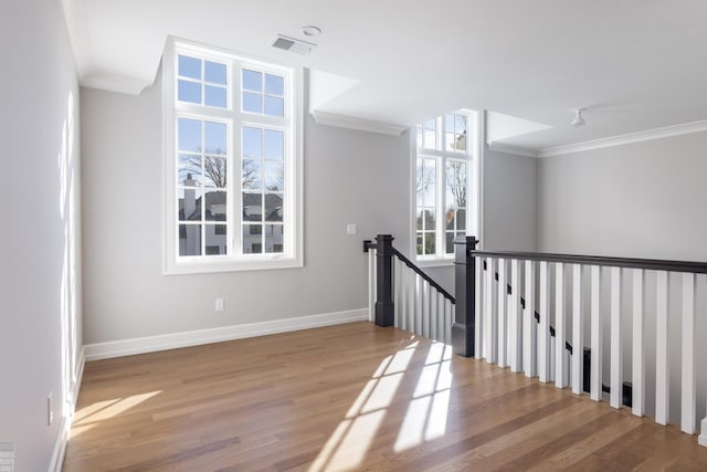 interior space featuring plenty of natural light, wood-type flooring, and ornamental molding