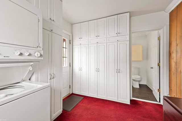 laundry room with dark hardwood / wood-style flooring and stacked washing maching and dryer